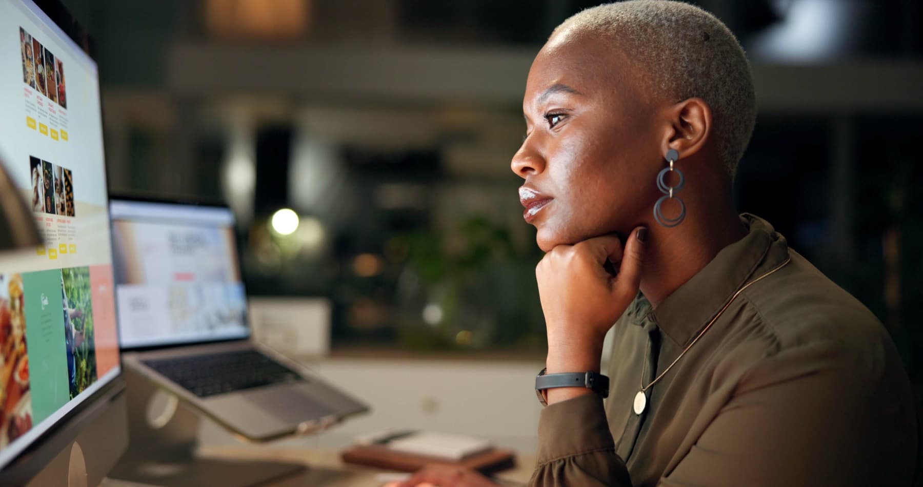 Black woman working at a computer at night